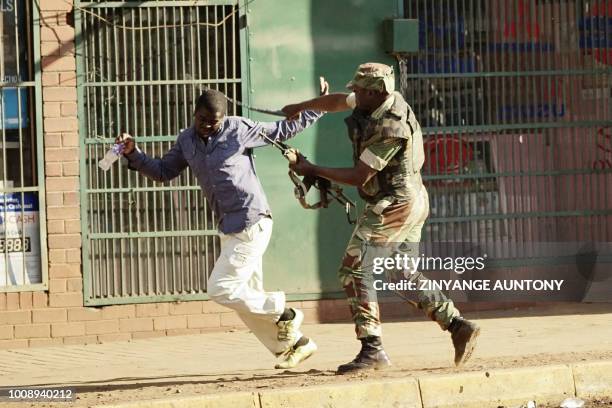 Zimbabwean soldier beats a man in a street of Harare on August 1, 2018 as protests erupted over alleged fraud in the country's election. One man was...