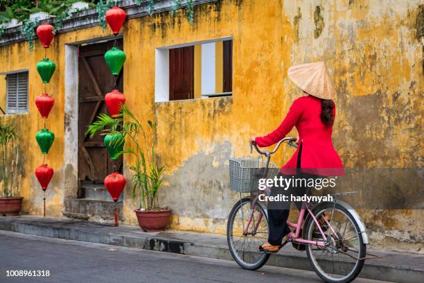 vietnamese vrouw rijden een fiets, een oude stad in een stad, vietnam hoi - hoi an stockfoto's en -beelden