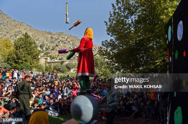 Afghan children cheer and react as they watch a performance of The Mobile Mini Circus for Children at the Bagh-e-Babur Garden, in Kabul, on August 1,...