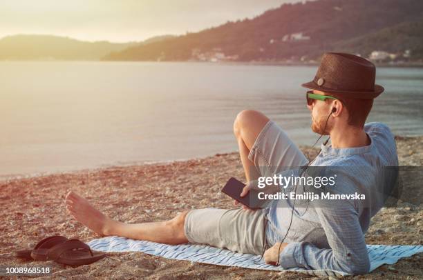 handsome man listening music and looking at the sea - salazar bronwich testify at hearing on re organization of mms stockfoto's en -beelden
