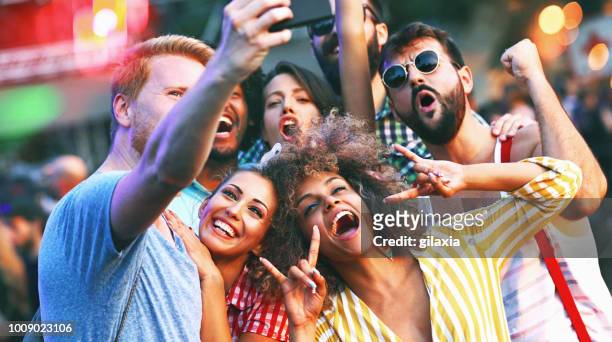 friends snapping selfies. - festival selfie stock pictures, royalty-free photos & images