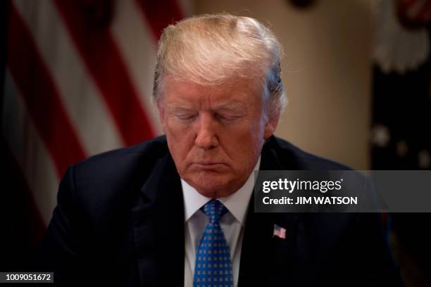 President Donald Trump prays while meeting with inner city pastors at the White House in Washington, DC,on August 1, 2018.