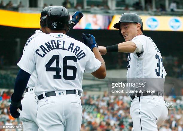 Jim Adduci of the Detroit Tigers celebrates with Jeimer Candelario after they scored against the Cincinnati Reds on a double by Jose Iglesias during...