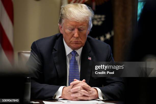 President Donald Trump prays during a meeting with inner city pastors in the Cabinet Room of the White House on August 1, 2018 in Washington, DC.
