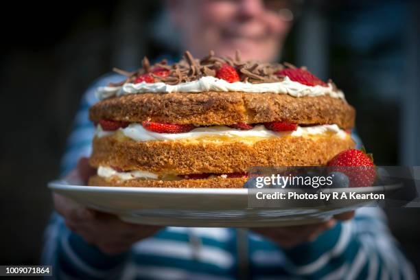 homemade strawberry cream cake - back of womens heads stock-fotos und bilder