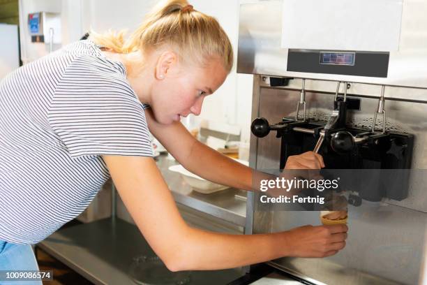 young woman making a soft serve ice cream from a machine - mr whippy ice cream stock pictures, royalty-free photos & images