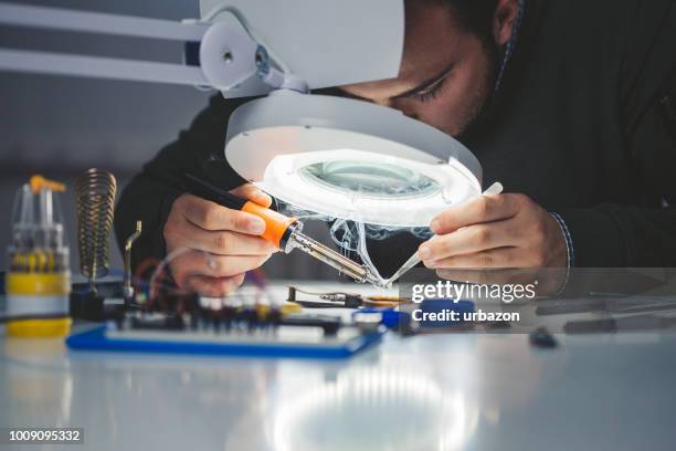 ingenieur bei der arbeit - lötkolben stock-fotos und bilder