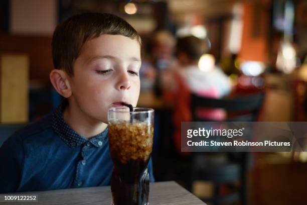 boy drinking sugary drink - coke stock-fotos und bilder