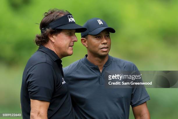 Phil Mickelson and Tiger Woods meet during a preview day of the World Golf Championships - Bridgestone Invitational at Firestone Country Club South...