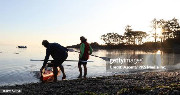 kayaking couple float kayak in ocean shallows - victoria canada stock pictures, royalty-free photos & images