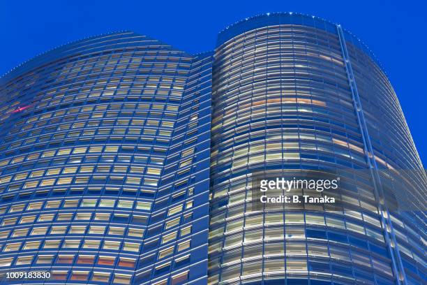 twilight illumination at roppongi hills mori tower in the upscale roppongi district of tokyo, japan - roppongi hills stock pictures, royalty-free photos & images