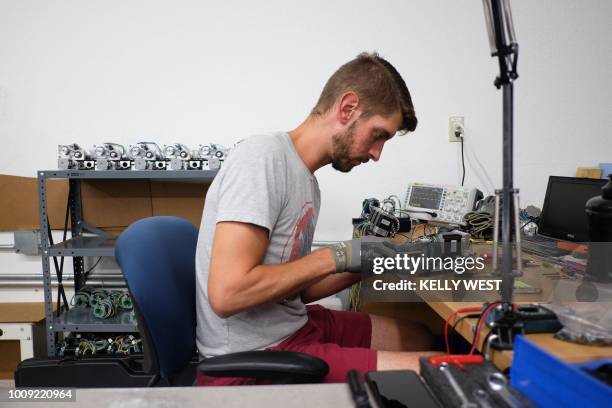 Caleb Tapp works on a motor assembly for a Ghost Gunner milling machine at the Defense Distributed factory in Austin, Texas on August 1, 2018. - The...