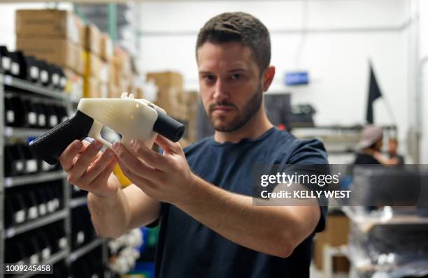 Cody Wilson, owner of Defense Distributed company, holds a 3D printed gun, called the "Liberator", in his factory in Austin, Texas on August 1, 2018....