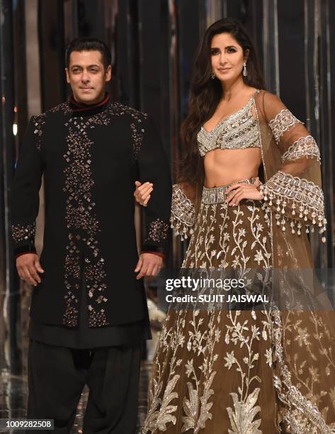 This picture taken on August 1, 2018 shows Bollywood actors Salman Khan and Katrina Kaif presenting creations by designer Manish Malhotra during a...