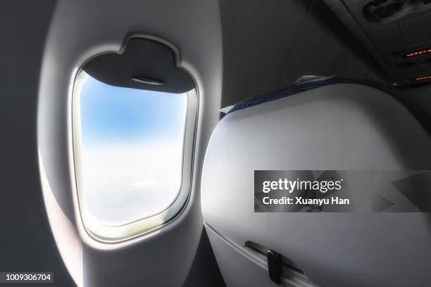 sky seen through airplane window - vehicle seat stock pictures, royalty-free photos & images