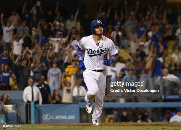 Yasmani Grandal of the Los Angeles Dodgers watches as the ball go for a two-run walk-off homerun over the right field fence in the tenth inning of...