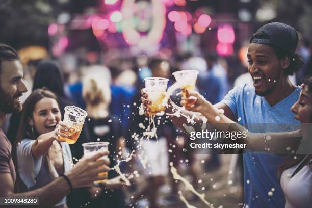 group of cheerful friends having fun with beer on a music concert. - spilled drink stock pictures, royalty-free photos & images