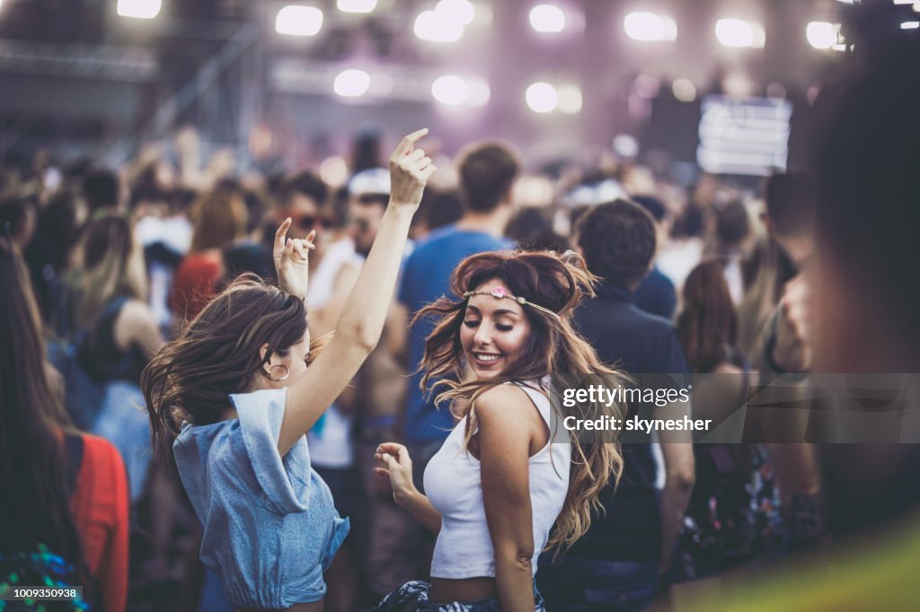 Happy women having fun while dancing on a music festival.