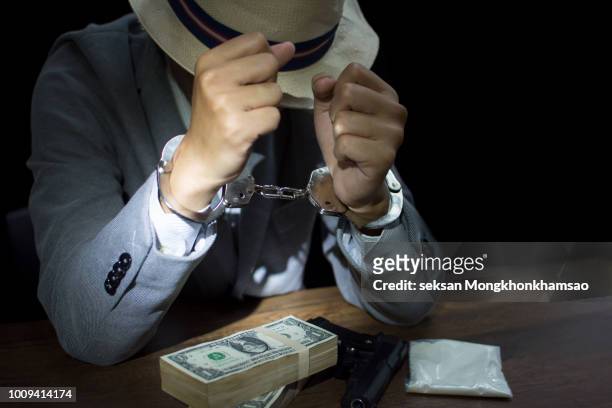suspect or criminal man with handcuffs being interviewed by detectives in interrogation room a suspected drug trafficking - cocaine, heroin - drug smuggling photos et images de collection