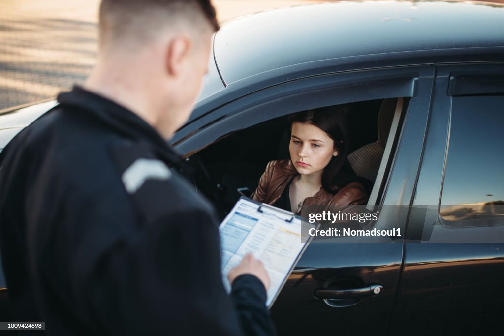 Policeman in uniform writes fine to female driver