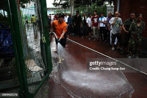 Firefighter sprays water in an alley of a slum area on August 2, 2018 in Seoul, South Korea. South Korea grappled with a heat wave in recent weeks...