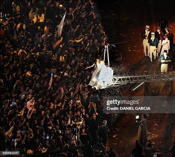 Argentines gather along 9 de Julio Avenue in Buenos Aires as an actress representing Argentina scatters confetti in Buenos Aires on May 25, 2010...