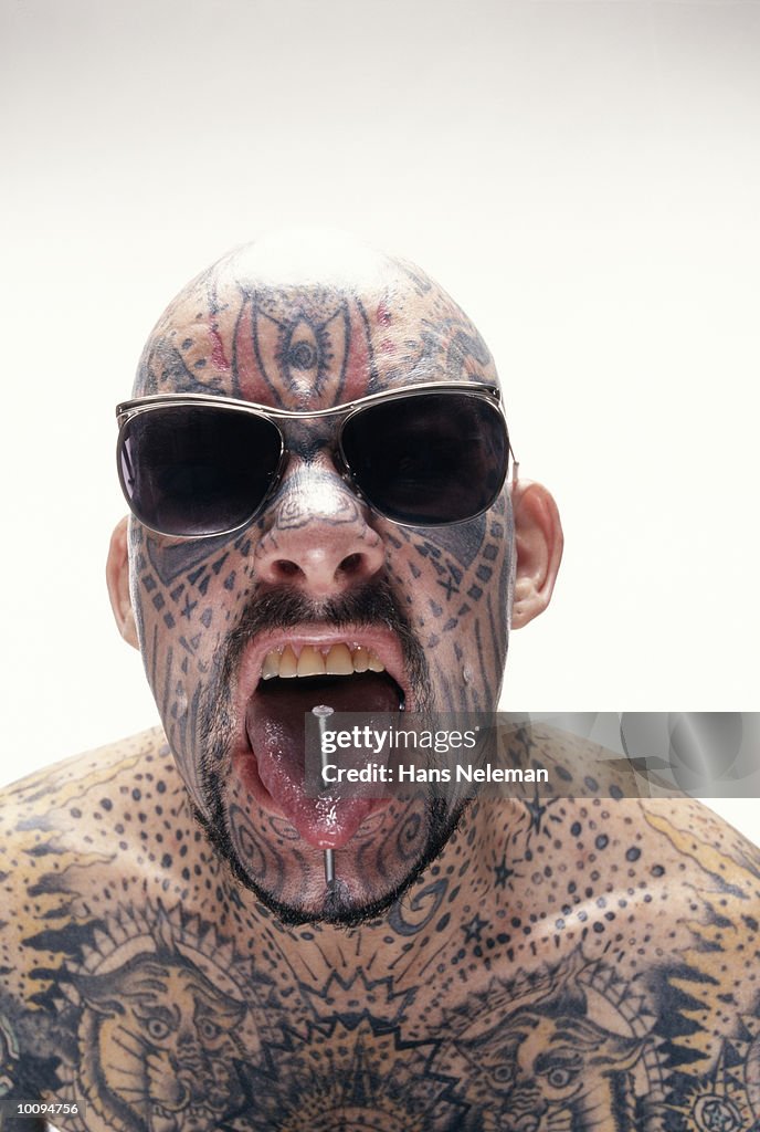 Man With Tattoo And Nail Through Tongue High-Res Stock Photo - Getty Images