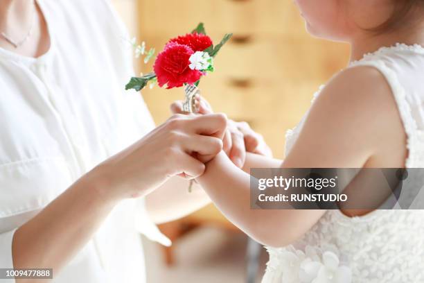 close up of daughter giving flower to mother - gift japan photos et images de collection