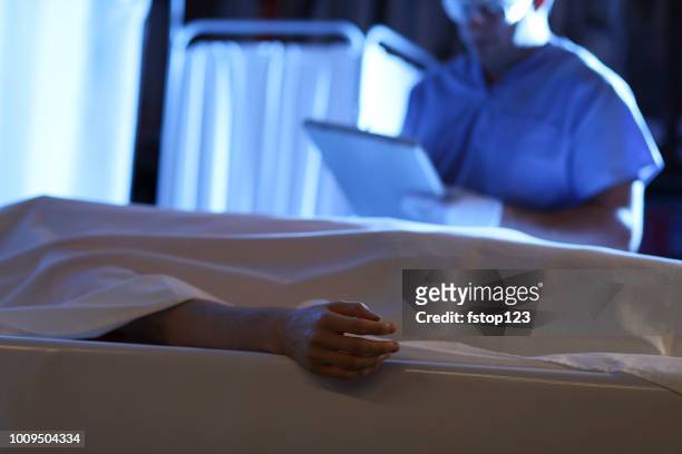 medical examiner with corpse in morgue. - dead body morgue stock pictures, royalty-free photos & images