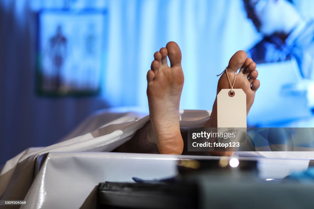 Médico legista com cadáver no necrotério.