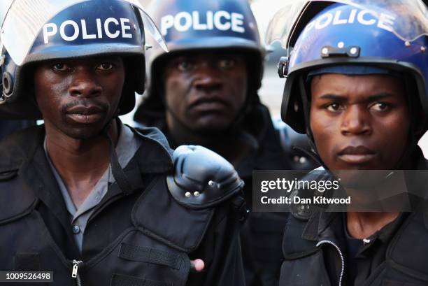 Zimbabwean riot police officers stand guard on an empty street on August 2, 2018 in Harare, Zimbabwe. Tension remains high following yesterday's...