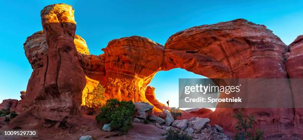 excursionista de pie en panorámica del arco de la torreta - arches national park fotografías e imágenes de stock