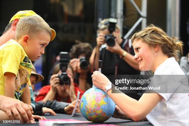 Round-the-world teen sailor Jessica Watson draws the path of her voyage on a globe for a young fan during a welcome home event at Queen Street Mall...