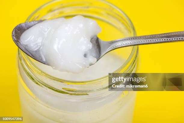 coconut oil in jar with spoon - kokosnussöl stock-fotos und bilder