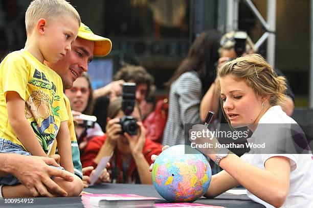 Round-the-world teen sailor Jessica Watson draws the path of her voyage on a globe for a young fan during a welcome home event at Queen Street Mall...