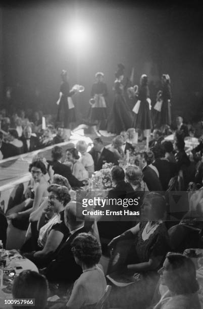 Guests and models at an evening ball and fashion show held at the Plaza Hotel, New York, 1956.