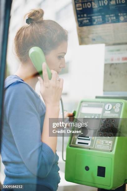 beautiful caucasian woman using telephone booth in japan - pay phone stock pictures, royalty-free photos & images