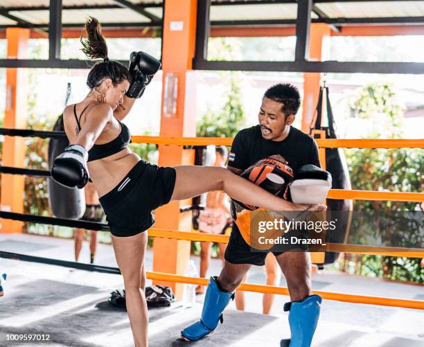 teamwork with personal trainer in muay thai camp in thailand - young woman using elbow punch - muaythai boxing stock pictures, royalty-free photos & images