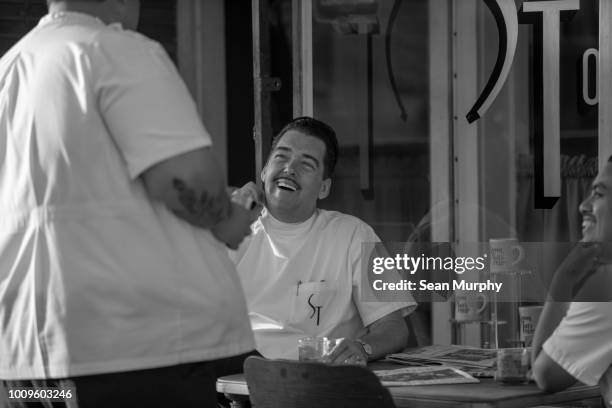 Barbers talking outside shop.