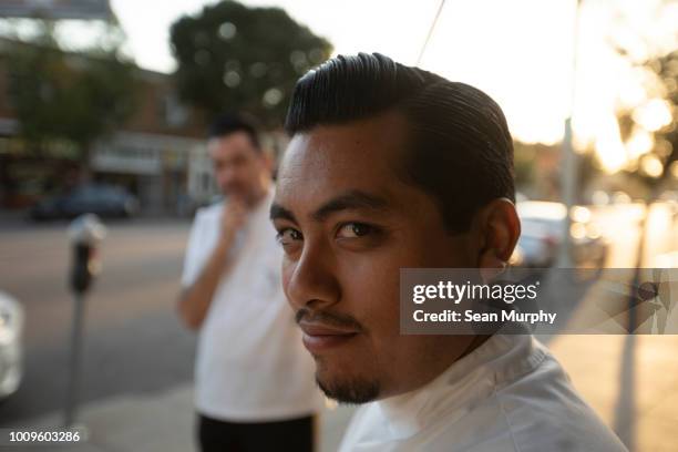 Two barbers outside the shop