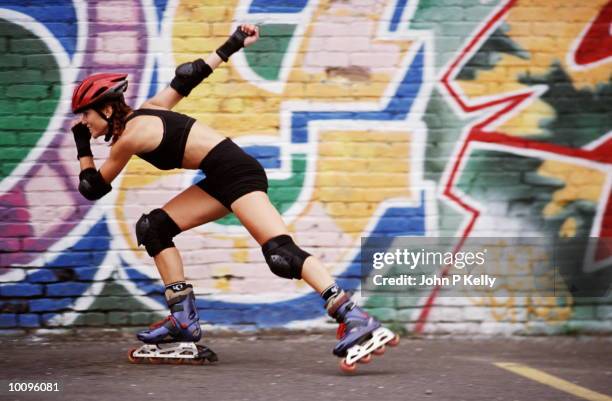 woman in-line skating past urban mural in colorado - skaten stockfoto's en -beelden