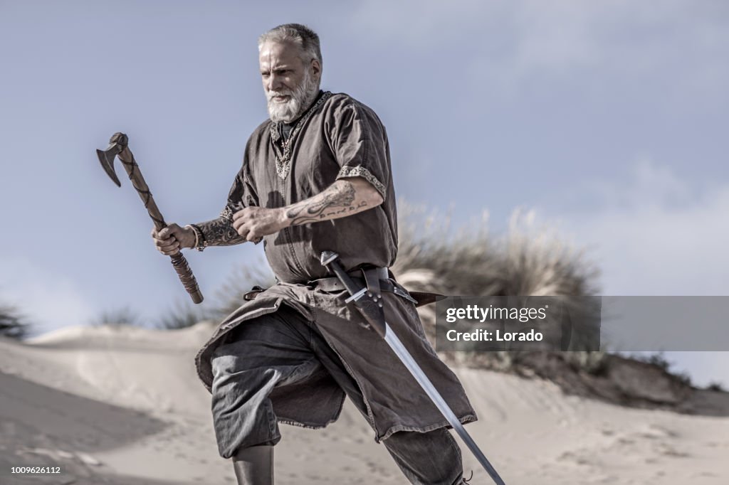 An individual viking warrior in action on a sandy battlefield dune