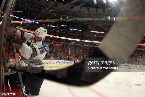Joe Thornton of the San Jose Sharks checks a Chicago Blackhawks player into the boards in Game Four of the Western Conference Finals during the 2010...