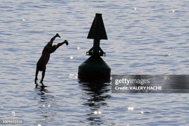 Man dives off a buoy into the Meditteranean Sea at Nice, south-eastern France on August 2 as heatwave conditions prevail over Europe.