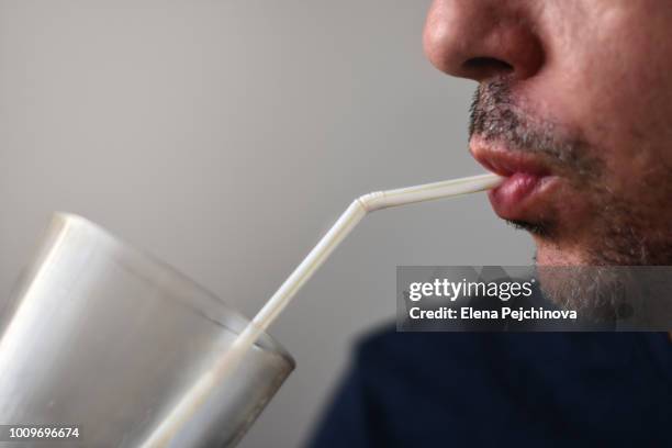 young man sipping coffee with a straw - straw stock-fotos und bilder