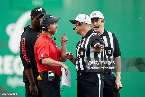 Head coach Dave Dickenson of the Calgary Stampeders discusses a penalty call with the officials in the game between the Calgary Stampeders and...