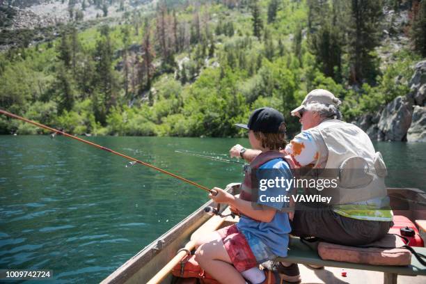 opa lehrer enkel zu fischen und ein boot an einem malerischen bergsee im sommer zu fahren. - mammoth stock-fotos und bilder