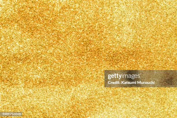 golden glitter powder texture background - gold glitter stockfoto's en -beelden