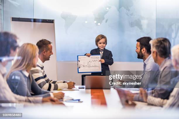 schattig business jongen tonen bedrijfsuitoefening team verslagen over een bijeenkomst in het kantoor. - kid presenting stockfoto's en -beelden