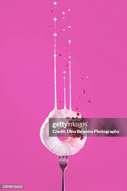 sprinkled pink donut with a dymanic splash of pink glazing on a vibrant hot pink background. flying food concept with copy space. - coberto de camada lustrosa - fotografias e filmes do acervo